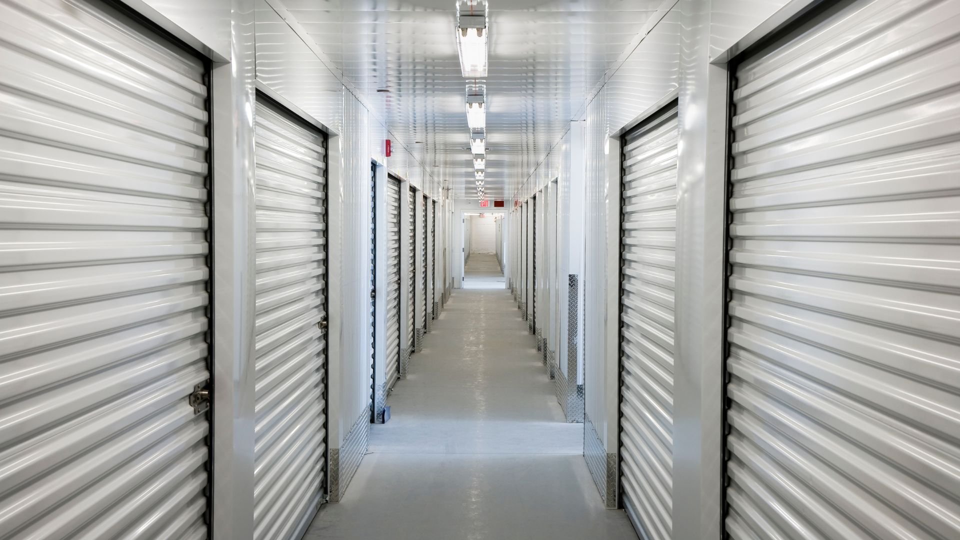 Interior of a clean, modern self-storage facility with white storage units