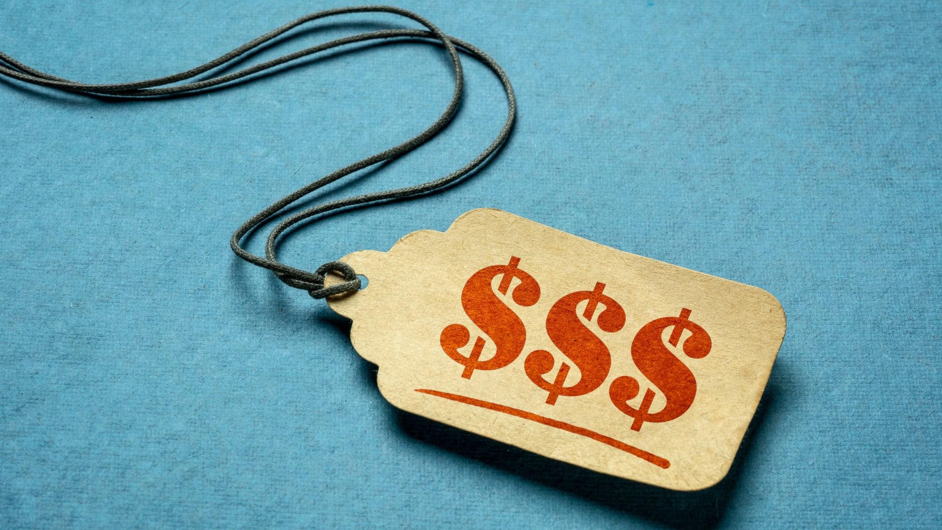 Price tag with three orange dollar signs on blue textured background