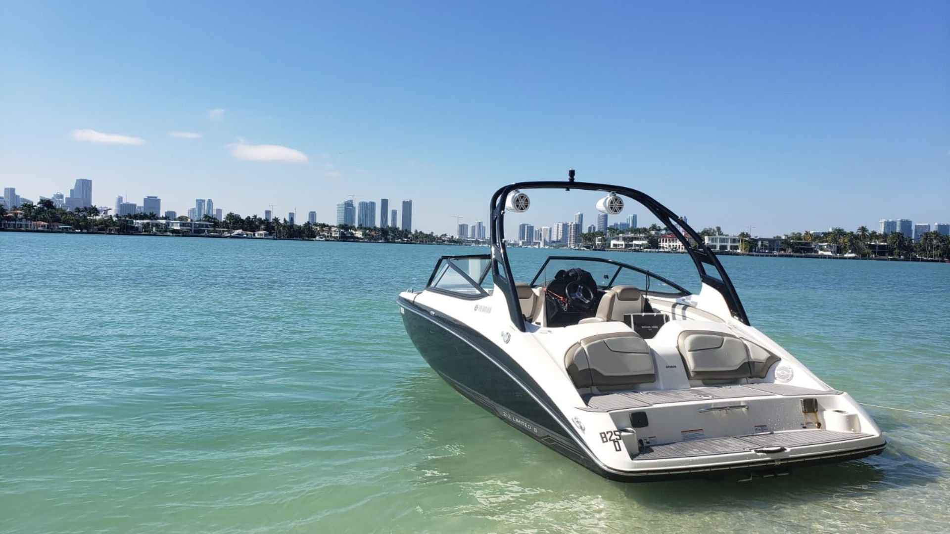 White speedboat on turquoise water with Miami skyline in background
