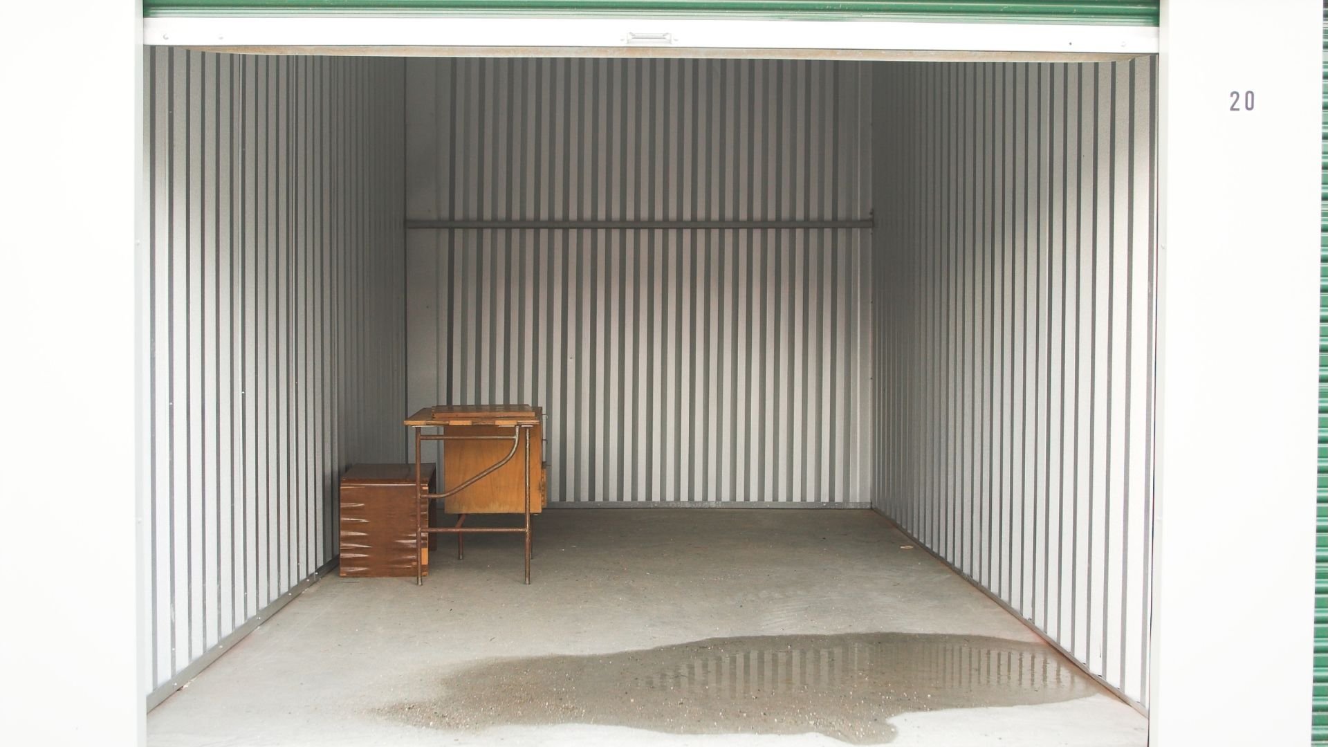 Empty storage unit with wooden desk and cabinet, numbered 20