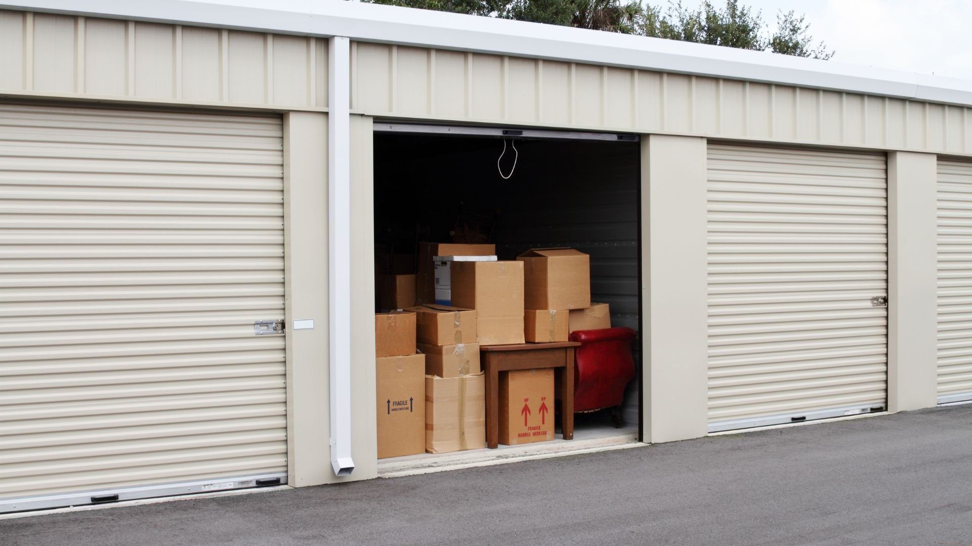 Open storage unit with cardboard boxes and a red item inside