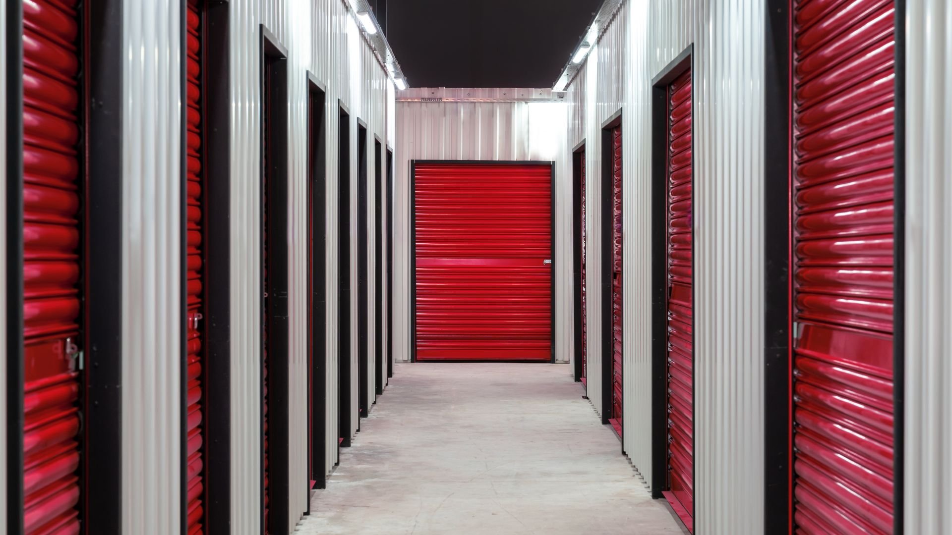 Interior hallway of self-storage facility with red and white storage units