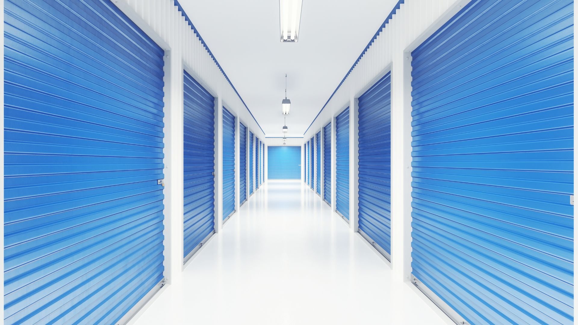 Clean storage facility hallway with blue doors and bright white interior